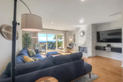 a living room with a blue couch and a fireplace at Luxury Coastal Escape | Sleeps 4 | Ocean Views + Resort Amenities in Carlsbad