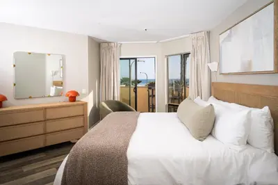 a bedroom with a bed and a dresser and a mirror at Pier View Sunset - Ocean Front, Patios, Location, Views in San Diego