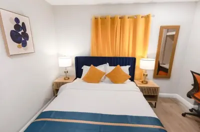 a bedroom with a bed with two lamps and a mirror at Escondido Front Unit 3-BR by SD STAY in Escondido