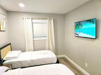 a room with two beds and a tv on the wall at Escondido Front Unit 3-BR by SD STAY in Escondido