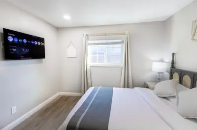 a white bedroom with a large bed and a flat screen tv at Escondido Front Unit 3-BR by SD STAY in Escondido