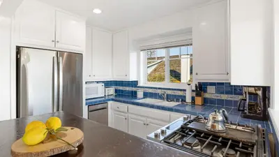 a kitchen with white cabinets and a counter top at Oceanfront Atelier by AvantStay Beachfront Balboa Peninsula Escape in Newport Beach