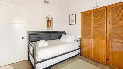 a bedroom with a bed and a wooden closet at Oceanfront Atelier by AvantStay Beachfront Balboa Peninsula Escape in Newport Beach