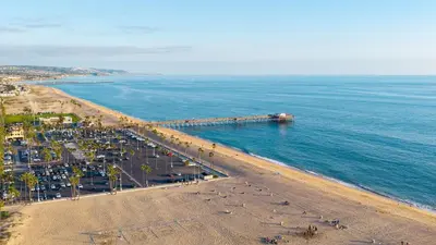 an aerial view of a beach with a pier at Oceanfront Atelier by AvantStay Beachfront Balboa Peninsula Escape in Newport Beach