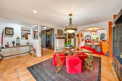 a living room with a glass table and red chairs at Gather and Unwind Outdoors, Stylish Vista Retreat! in Vista