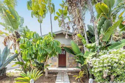a house with a door in the middle of trees at Vintage Beach Bungalow in Oceanside