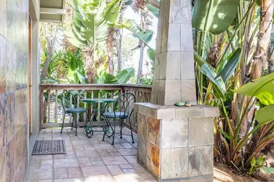 a porch with chairs and a table and some plants at Vintage Beach Bungalow in Oceanside