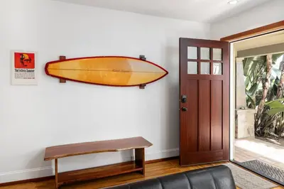 a surfboard hanging on a wall next to a door at Vintage Beach Bungalow in Oceanside
