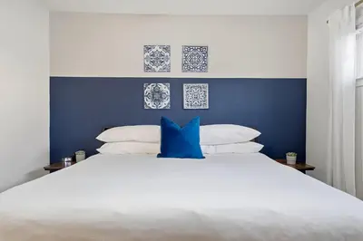 a bedroom with a large white bed with blue walls at 4BR Family Retreat with Hot Tub Games & Fire Pit in Chula Vista