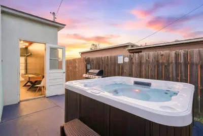 a hot tub in a backyard with a fence at 4BR Family Retreat with Hot Tub Games & Fire Pit in Chula Vista