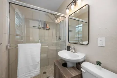 a bathroom with a sink and a shower with a mirror at Stylish 1BR Home with Parking Near Zoo & Downtown in San Diego