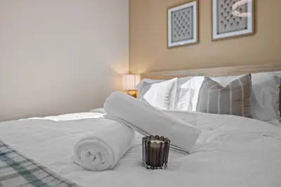 a white bed with towels on top of it at Stylish 1BR Home with Parking Near Zoo & Downtown in San Diego