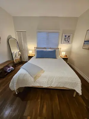 a bedroom with a large white bed with blue pillows at The Seabreeze by Coastline Vacation Rentals in San Diego
