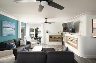 a living room with a couch and a ceiling fan at Blue Tide by Coastline Vacation Rentals in San Diego