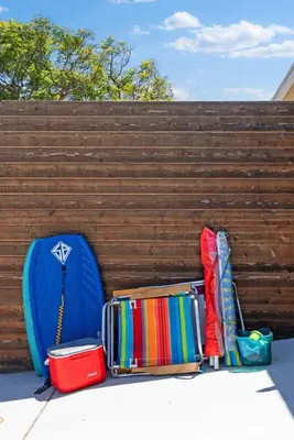 a pile of luggage and umbrellas next to a fence at Serena Encinitas by Coastline Vacation Rentals in Encinitas
