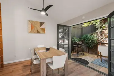 a dining room with a wooden table and white chairs at The Artist's Loft by Coastline Vacation Rentals in San Diego