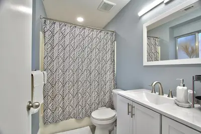 a bathroom with a toilet and a sink and a mirror at Modern Design Temecula House-30 in Temecula