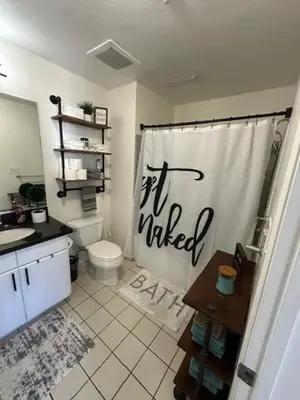 a bathroom with a toilet and a shower curtain at Stylish Gaslamp 1BR Den Patio Walk Everywhere in San Diego