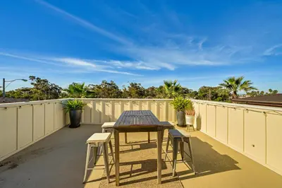 a patio with a table and chairs on a balcony at 1 Mi to Beach! San Clemente Gem with Rooftop Patios in San Clemente