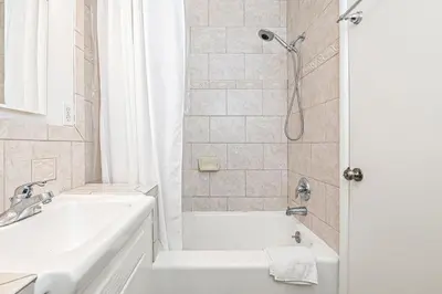 a bathroom with a tub and a sink and a shower at Bayfront 2Br With Harbor Views, Only Steps To The Sand By Beachview Rentals in Newport Beach