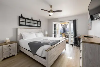 a bedroom with a large bed with a ceiling fan at Walk To Ponto Beach - Surf and Relax in Carlsbad