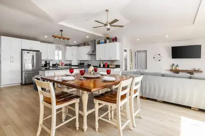 a kitchen and dining room with a wooden table and chairs at Walk To Ponto Beach - Surf and Relax in Carlsbad