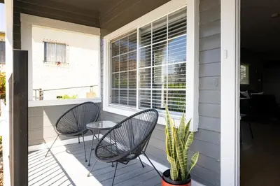 a porch with two chairs and a table and a window at The Urban Den by Coastline Vacation Rentals in San Diego
