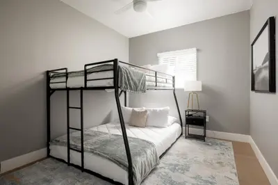 a bedroom with two bunk beds with white walls at The Urban Den by Coastline Vacation Rentals in San Diego