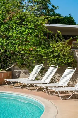 two white lounge chairs next to a swimming pool at Skyline Vista by Coastline Vacation Rentals in San Diego