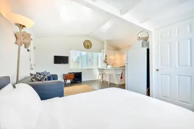 a room with a bed and a kitchen with a refrigerator at Beach Break by Coastline Vacation Rentals in San Diego