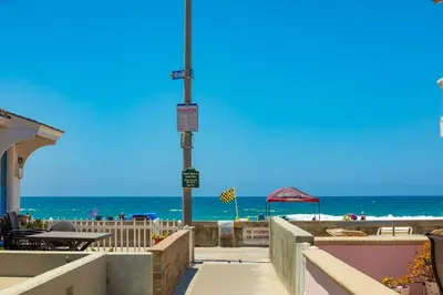 a walkway to a beach with the ocean in the background at Beach Break by Coastline Vacation Rentals in San Diego