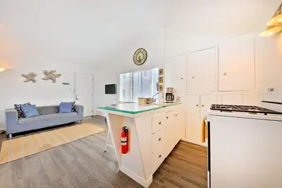 a kitchen with white cabinets and a counter top at Beach Break by Coastline Vacation Rentals in San Diego