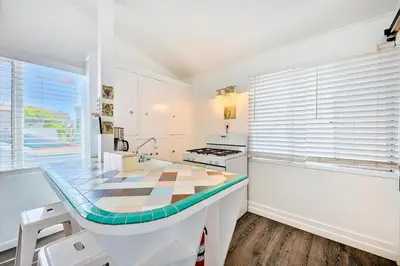 a kitchen with a counter with a table in it at Beach Break by Coastline Vacation Rentals in San Diego