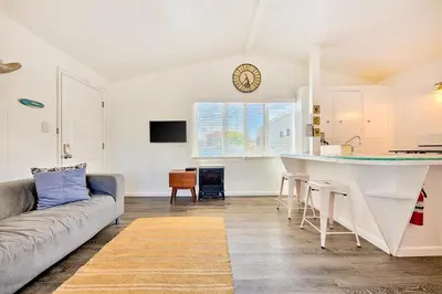 a kitchen and living room with a couch and a counter at Beach Break by Coastline Vacation Rentals in San Diego