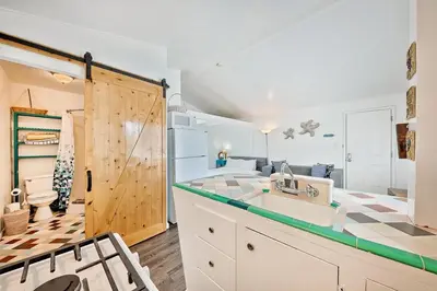 a kitchen with a sink and a sliding barn door at Beach Break by Coastline Vacation Rentals in San Diego
