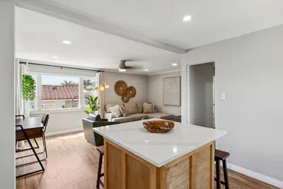 a kitchen and living room with a couch and a table at Bohemian Seaside by Coastline Vacation Rentals in San Diego