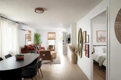 a living room with a table and a bedroom at Casa del Sol by Coastline Vacation Rentals in San Diego