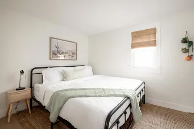 a white bedroom with a bed and a window at Casa del Sol by Coastline Vacation Rentals in San Diego
