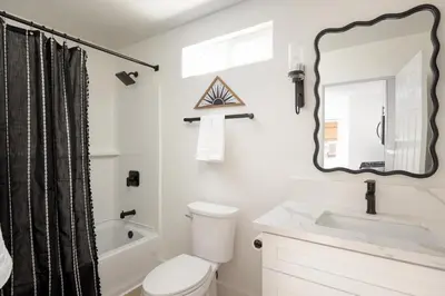 a bathroom with a toilet and a sink and a mirror at Casa del Sol by Coastline Vacation Rentals in San Diego
