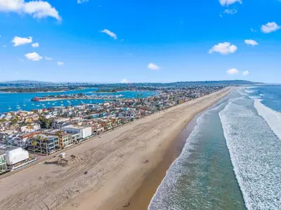 an aerial view of a beach with buildings and the ocean at The Sands by Coastline Vacation Rentals in San Diego