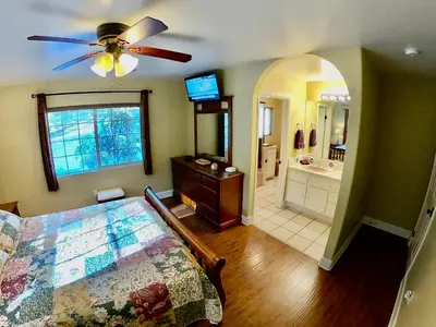 a bedroom with a bed with a ceiling fan and a bathroom at Villa La Cresta - 5 Acre Retreat in Murrieta