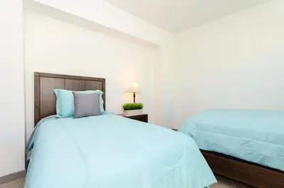 a bedroom with two beds with blue pillows at Spacious 3bed Apt with pool close to SDCC in San Diego
