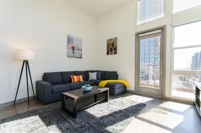 a living room with a blue couch and a table at Snazzy 2BR Near Petco Park & Convention Center in San Diego
