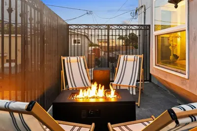 two chairs and a fire pit on a balcony at Vintage Surf Hut by Coastline Vacation Rentals in San Diego
