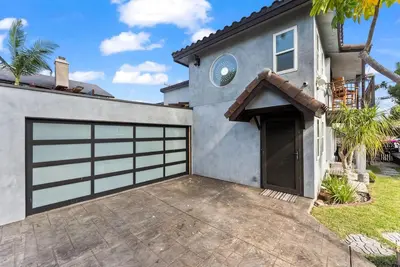 a garage door of a house with a driveway at Vintage Surf Hut by Coastline Vacation Rentals in San Diego