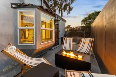 a patio with two chairs and a table and a window at Vintage Surf Hut by Coastline Vacation Rentals in San Diego