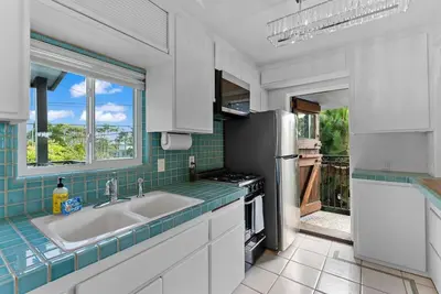 a kitchen with a sink and a refrigerator at Vintage Surf Hut by Coastline Vacation Rentals in San Diego
