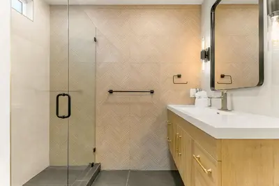 a bathroom with a shower with a sink and a mirror at PB Beach Compound - 2 New Homes Steps to Sand in San Diego