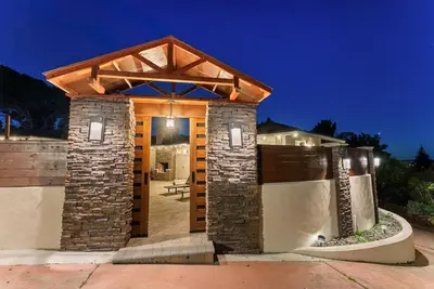 a house with a stone wall and a pavilion at Sunset Summit by Coastline Vacation Rentals in La Mesa
