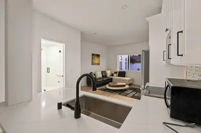 a kitchen with a living room with a couch at Spacious Modern Home with Rooftop & Private Backyard in Oceanside